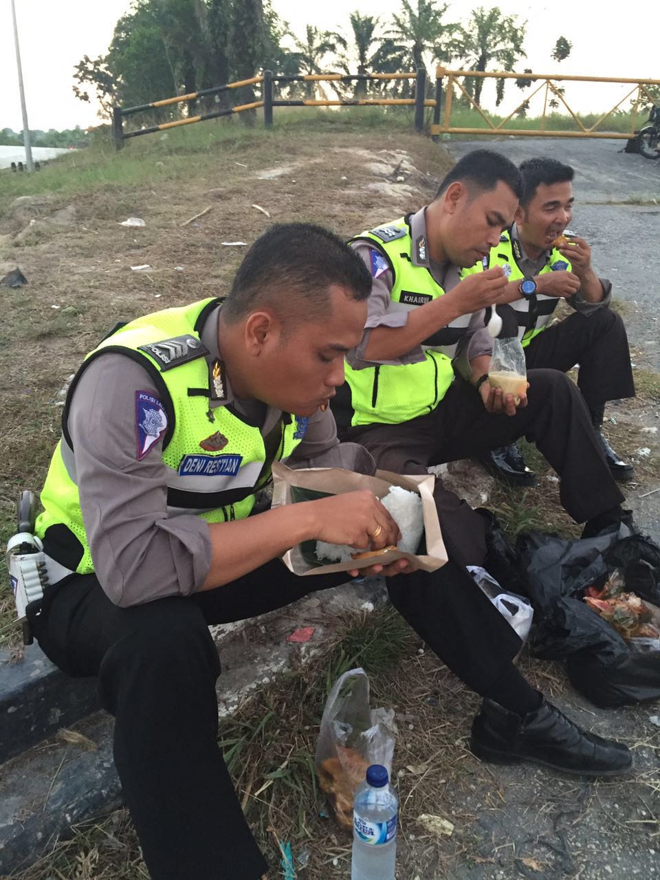 Aipda Khairul, Brigadir Deni, Brigadir Gandri sedang menyantap nasi bungkus usai berbuka puasa di posko pengamanan Minas