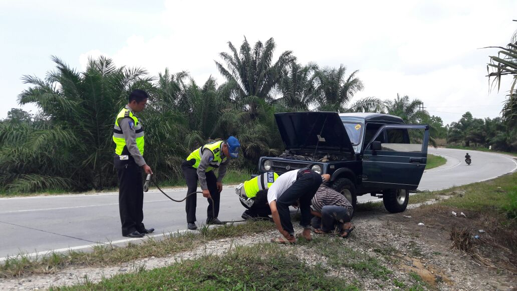 Tim patroli polantas polres Siak saat memberikan bantuan kepada masyarakat yang kendaraan nya mengalami kerusakan saat melintas di km 42 Minas 